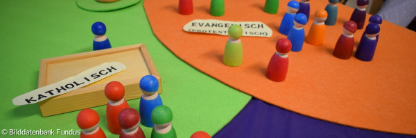 Ökumene mit Spielfiguren dargestellt